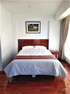 sypialnia z dużym łóżkiem z drewnianym zagłówkiem w obiekcie El SOL HOTEL - URUBAMBA w mieście Urubamba