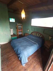 1 dormitorio con 1 cama con manta azul en Odisea, en Villa Serrana