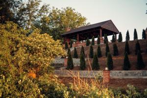 a gazebo in a park with trees at Madison Lake Villa in Baloteşti