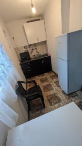 eine Küche mit einem weißen Kühlschrank und einem Stuhl in der Unterkunft Guest House NINI in Bordschomi