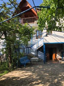 eine blaue Bank, die vor einem Gebäude sitzt in der Unterkunft Guest House NINI in Bordschomi