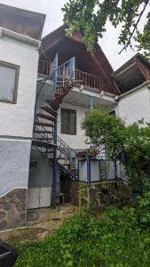 ein Haus mit seitlicher Wendeltreppe in der Unterkunft Guest House NINI in Bordschomi