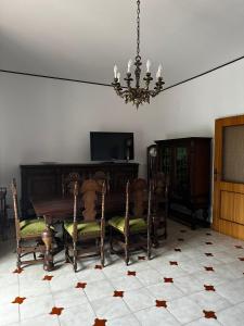 een eetkamer met een tafel en stoelen en een kroonluchter bij La Foresteria- Azienda agricola Garra in Mutignano