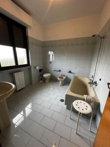 y baño con bañera, aseo y lavamanos. en La Foresteria- Azienda agricola Garra, en Mutignano