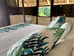 ein Bett mit blauen und weißen Kissen darauf in der Unterkunft The Cabanas Lamu in Lamu