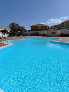 a large swimming pool with blue water at Villa Katerina in Caleta De Fuste