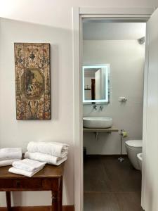 bagno con lavandino, servizi igienici e specchio di Affittacamere Medusa a Firenze