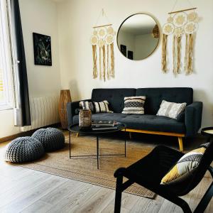 uma sala de estar com um sofá azul e um espelho em 15 mn de PARIS, perle rare avec vue - 2 chambres em Groslay