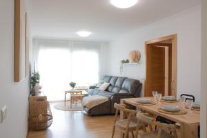 una sala de estar con una mesa y un sofá en Progreso Sanxenxo, en Sanxenxo