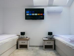 a room with two beds and a tv on the wall at Alda in Pyrzowice