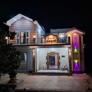 a house with a balcony with purple and green lights at Shree Radhakrishn Homestay Tarkarli Malvan in Malvan