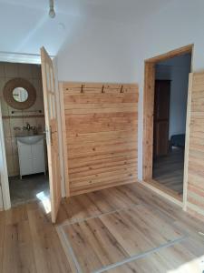 a large wooden door in a room with wooden floors at Chatka Kurki in Kurki