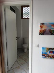 uma casa de banho com WC e uma pintura na parede em Casa Mia em Vlorë