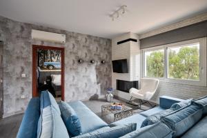 ein Wohnzimmer mit einer blauen Couch und einem Kamin in der Unterkunft Mons Villa in Kalathas