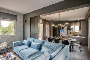 ein Wohnzimmer mit einer blauen Couch und einer Küche in der Unterkunft Mons Villa in Kalathas