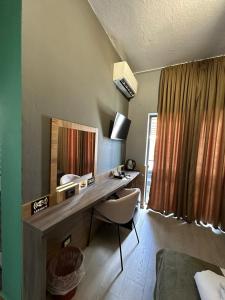 a room with a desk with a mirror and a chair at VILLA CABARE Apartments&Rooms in Durrës
