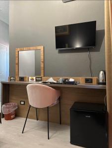 a desk with a television and a chair in a room at VILLA CABARE Apartments&Rooms in Durrës