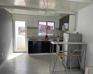 een keuken met een aanrecht en een aantal stoelen. bij Apartamento in Praia