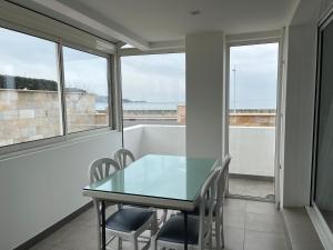 a dining room with a table and chairs and windows at Hôtel Valencia in Hendaye