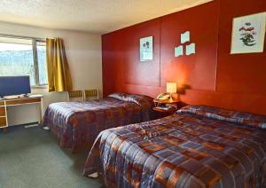 Cette chambre comprend deux lits et une télévision. dans l'établissement Cozy Corner Motel & Restaurant, à Haines Junction