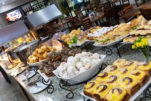 uma padaria com muitos tipos diferentes de pastelarias em exposição em Hotel Dan Inn Franca & Convenções em Franca