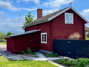 a red house with a blue fence in front of it at Villa Wargquist in Djuras +10 photos