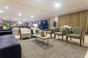 poczekalnia z krzesłami i stołami oraz salon w obiekcie Hotel Dan Inn Franca & Convenções w mieście Franca
