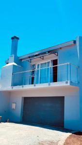 a blue building with a garage door and a balcony at Sunset View Self- Catering Yzerfontein in Yzerfontein +10 photos