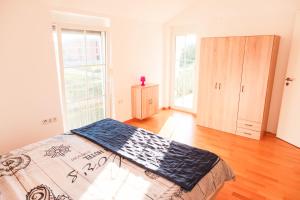 Un dormitorio con una cama en una habitación con ventanas. en Villa Luka Sukošan, en Sukošan