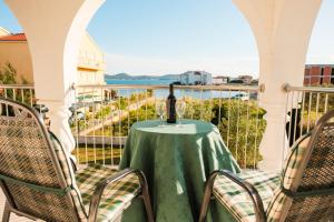 Una mesa y sillas en un balcón con vista al mar. en Villa Luka Sukošan, en Sukošan