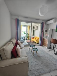 sala de estar con sofá y mesa en Studio Vanille - Vue Mer en Saint-Denis