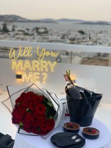 Um buquê de rosas vermelhas e uma mensagem de casamento. em She Mykonos - The Residency em Míconos