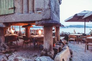 a restaurant with tables and chairs and the ocean at Aliving Colo in Raxó