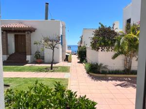 una pasarela entre dos edificios con el océano en el fondo en Pirata Bungalow sea front, en Estepona