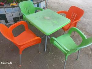 4 Stühle und ein Tisch mit einem grünen Tisch in der Unterkunft Green Oasis Holiday Home Vlore in Vlorë