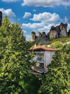 a building in the middle of a mountain with trees at Boutique St Stephens Residence in Kalabaka