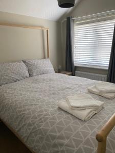 uma cama com duas toalhas num quarto em Modern 2-Bed House and Parking Tibshelf Derbyshire em Alfreton