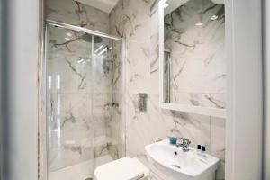 a white bathroom with a shower and a sink at ML Apartments in Vieste +17 photos