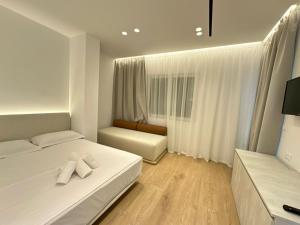 1 dormitorio blanco con 2 camas y ventana en Villa Mucho, en Sarandë