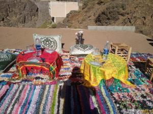 a blanket with two tables on top of a beach at riad atlas imnane in Imlil