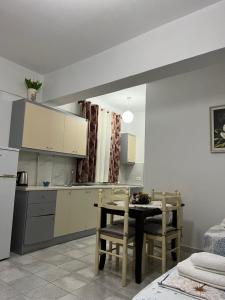 a kitchen and dining room with a table and chairs at Dea Apartament in Ksamil
