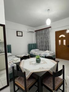 a room with two beds and a table and chairs at Dea Apartament in Ksamil +24 photos