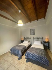 a bedroom with two beds and a ceiling at Gialos Villas 1-2 in Mikros Gialos