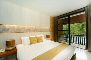 a bedroom with a large bed and a window at Sukhothai Treasure Resort & Spa- SHA Plus Certified in Sukhothai