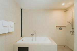 y baño blanco con bañera y ducha. en Sukhothai Treasure Resort & Spa- SHA Plus Certified en Sukhothai