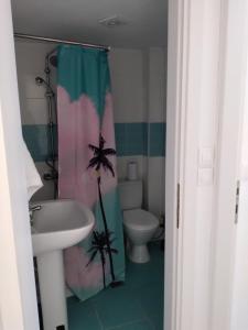 ein Badezimmer mit einem Duschvorhang, einem Waschbecken und einem WC in der Unterkunft Maisonette Fanari in Fanárion