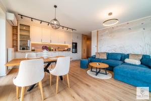 a living room with a blue couch and a table at Lake Rental P R A T U M 45 in Mikołajki