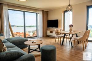 a living room with a couch and a table at Lake Rental P R A T U M 45 in Mikołajki