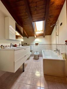 a bathroom with a sink and a tub and a toilet at Kibilu - Villa near Lake Maggiore and Varese in Lomnago
