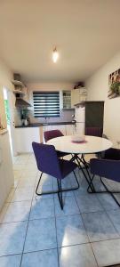 a kitchen with a table and chairs in a room at Apartments Ita - Postira in Postira